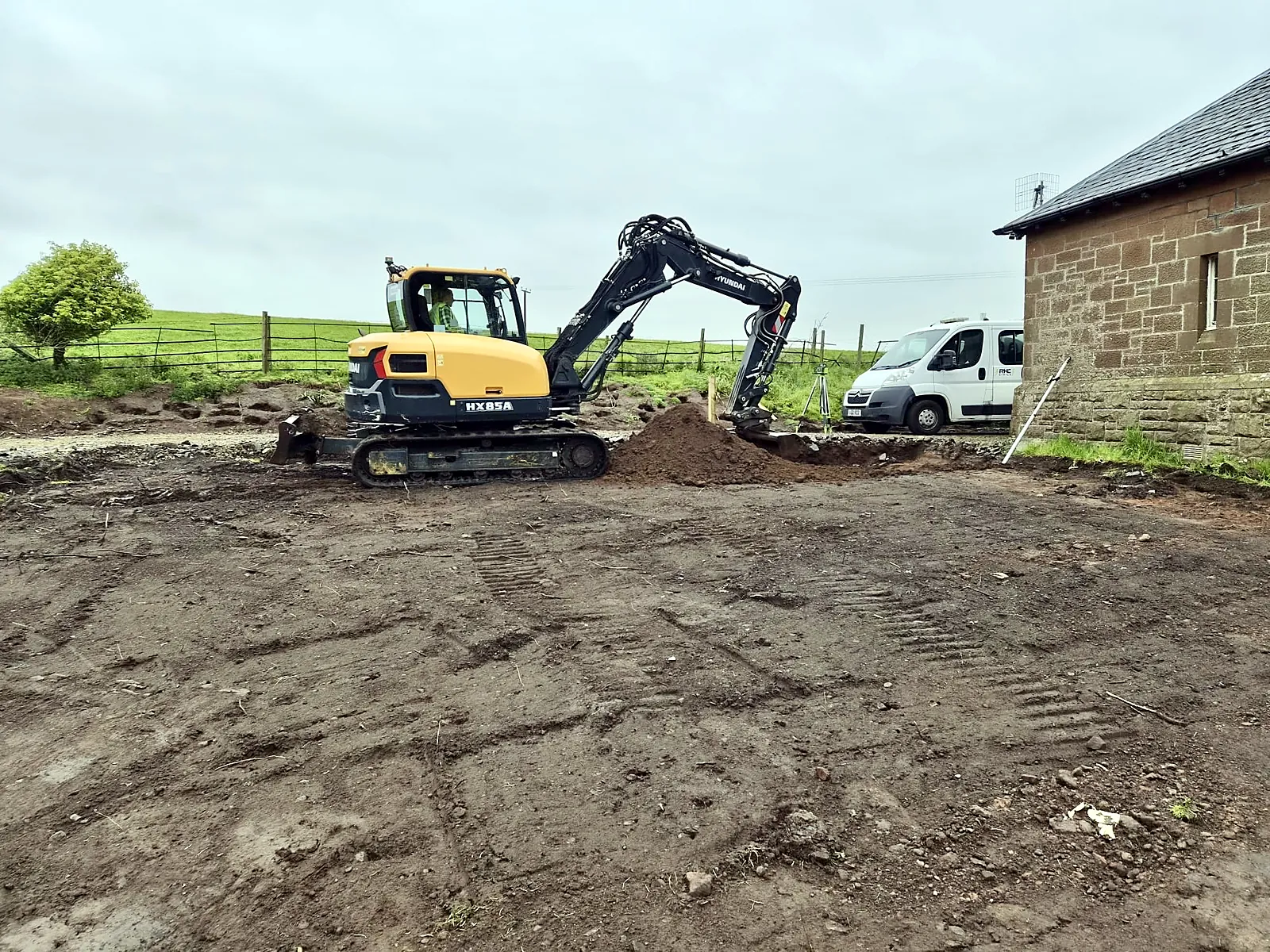 Excavator clearing ground for a new extension