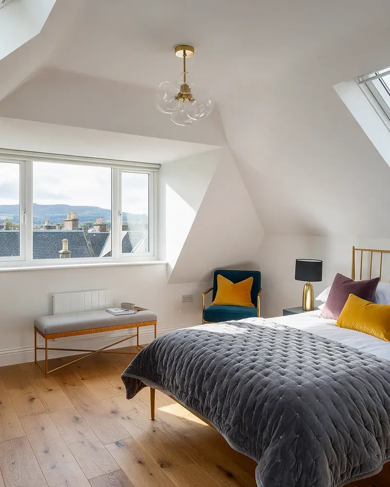 Bright loft conversion bedroom with dormer window and roof lights (illustrative image)